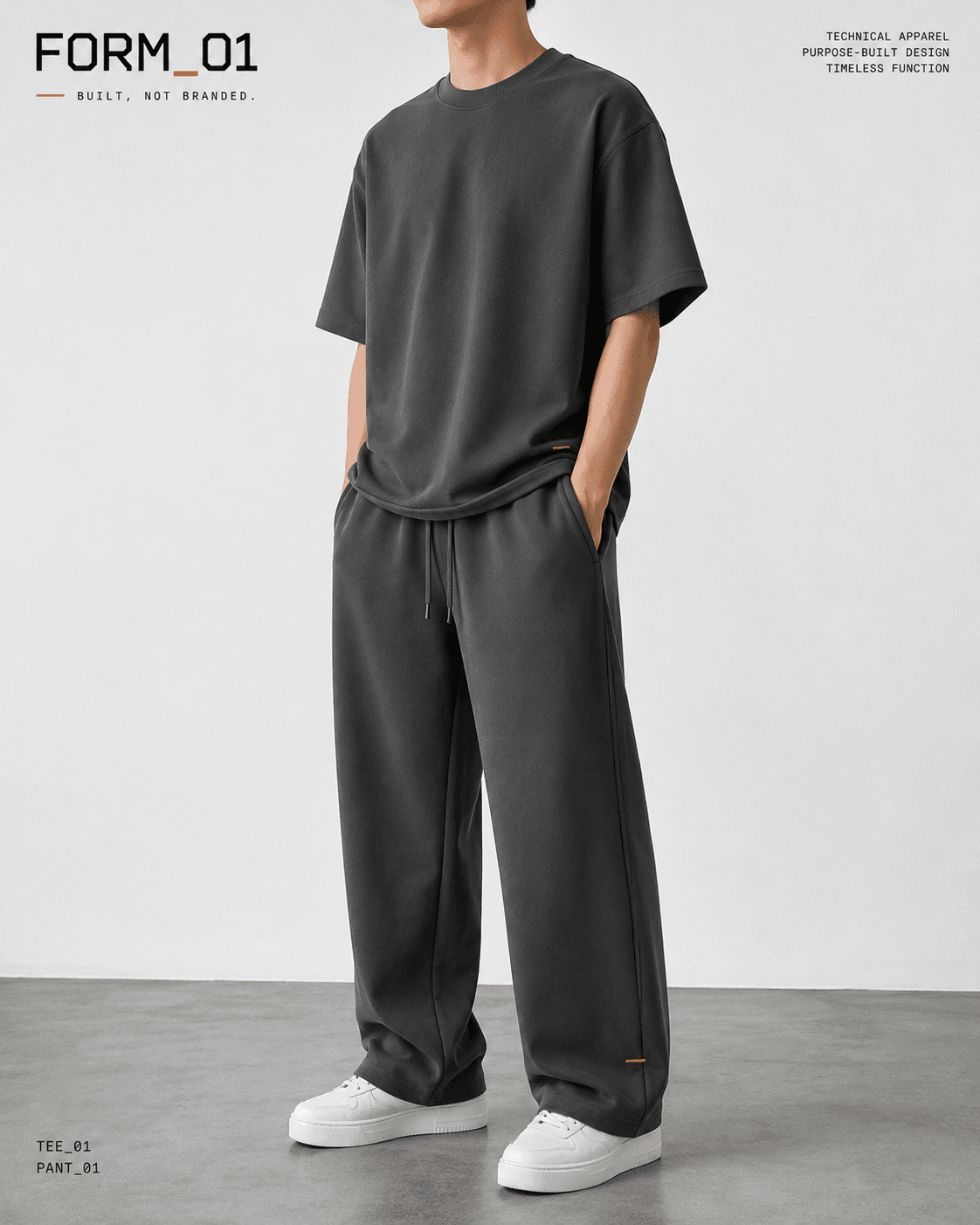Model wearing the graphite FORM_01 TEE_01 and PANT_01 system